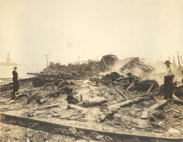 Photo: Two men standing next to wreckage extending into the distance.