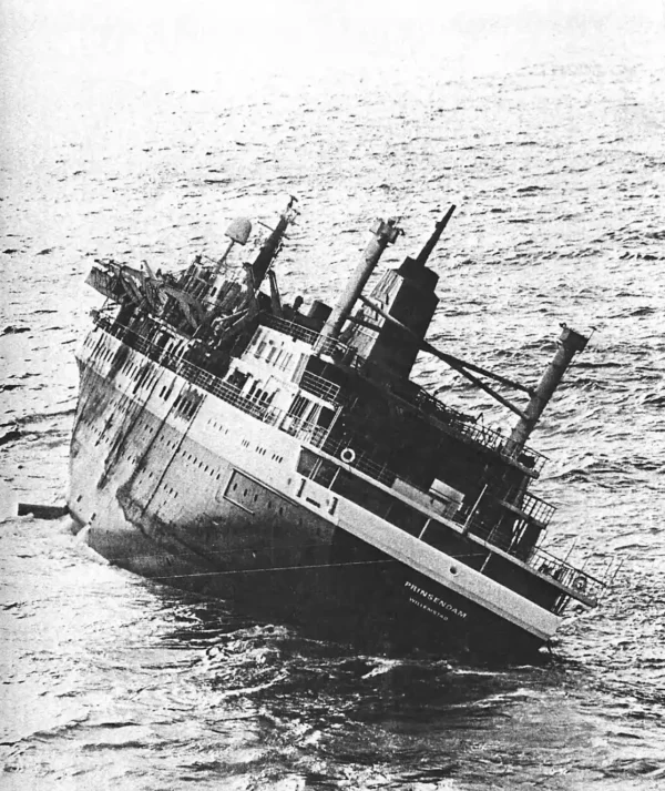 Photo from Commandant’s Bulletin, Prinsendam leaning with its starboard side in the water.