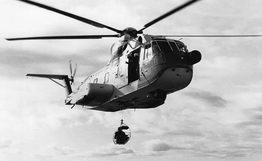A vintage photo of a Coast Guard HH-3F “Pelican” making a hoist at sea.