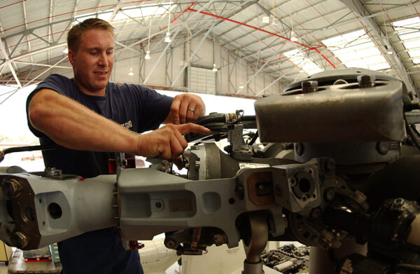 Photo: PO2 Ryan J. Parker, 26, of Gibsonburg, Ohio, performs routine maintenance on an HH-60 Jayhawk helicopter.