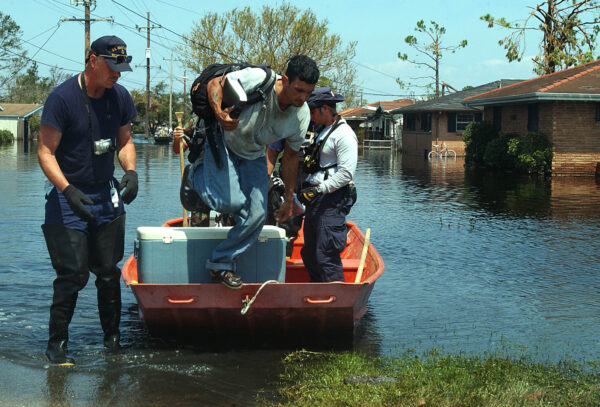Photo: A victim of Hurricane Katrina jumps to land from a Coast Guard boat.