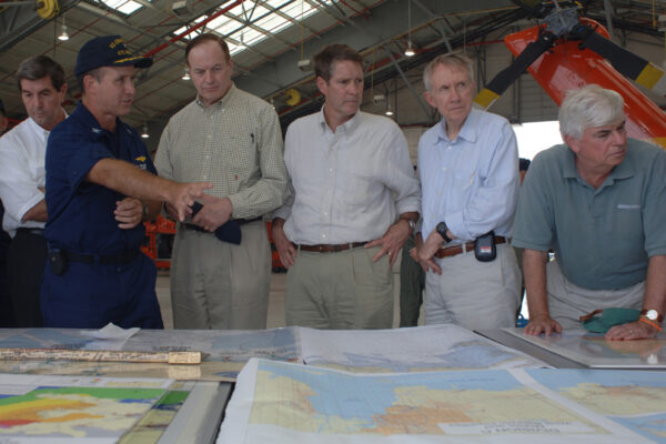 Photo: Capt. David Callahan standing at maps with the Governor and a Senate delegation.