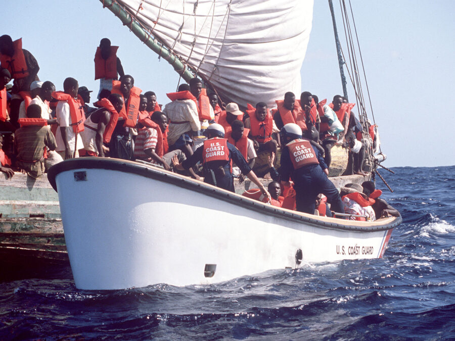 Photo: Haitian refugees scramble to get aboard a Coast Guard small boat after spending several days at sea.