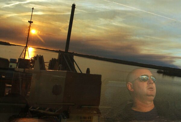 Photo: Reflection of view from the bridge with crewmember visible through the glass.
