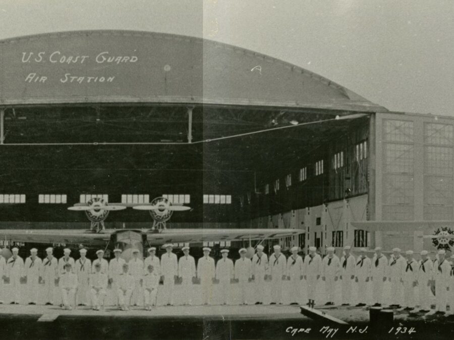 A 1934 panoramic photograph of Coast Guard Air Station Cape May with hangars, personnel, and aircraft.