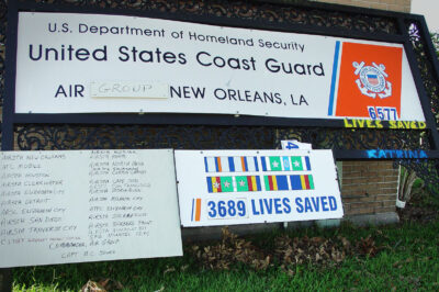 Photo: U.S. Coast Guard Air Station New Orleans sign leaning against a building after hurricane Katrina made landfall in August 2005.