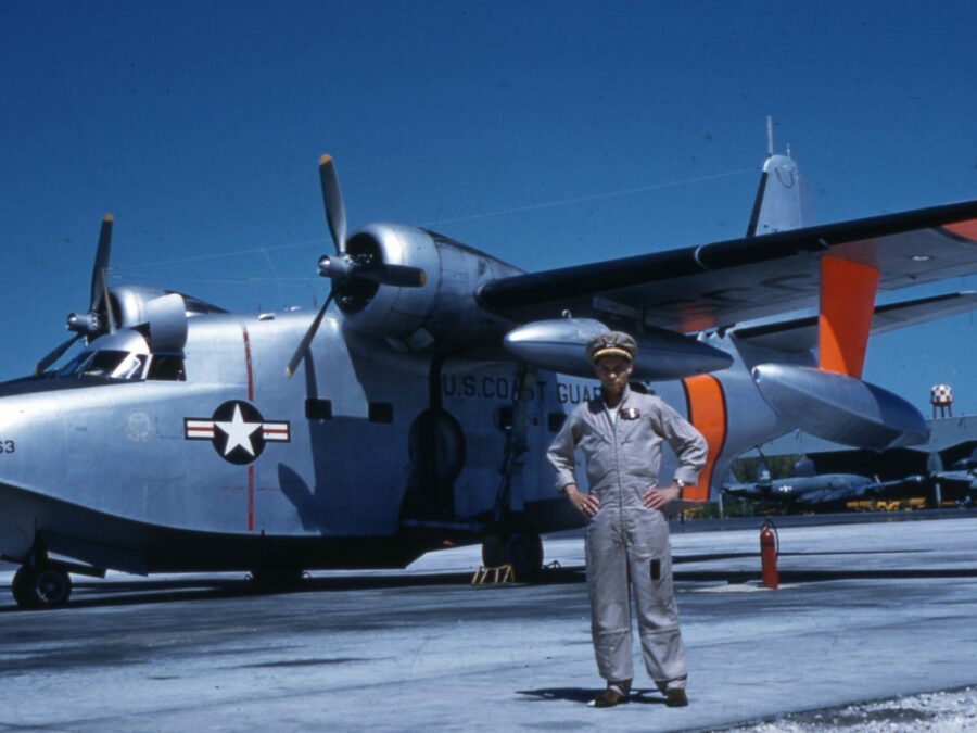 Photo: LTJG Bobby Wilks posing in front of an HU-16E “Albatross” fixed-wing amphibian aircraft.