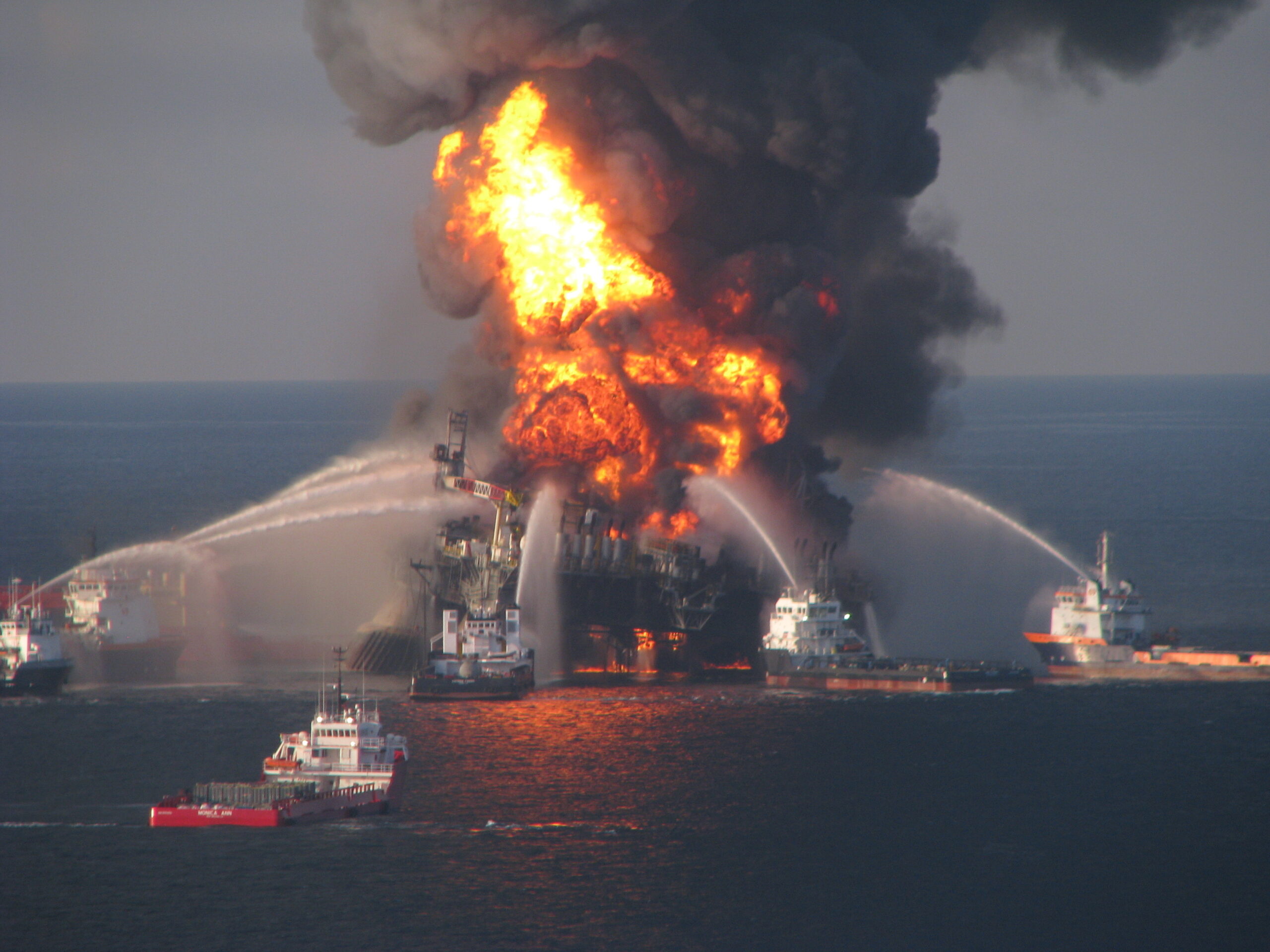 Photo: Ships shoot water at the fiery oilrig.