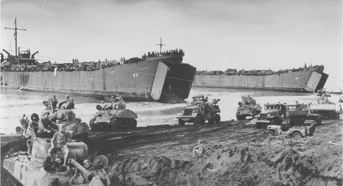 Photo: Two LST's unload tanks.