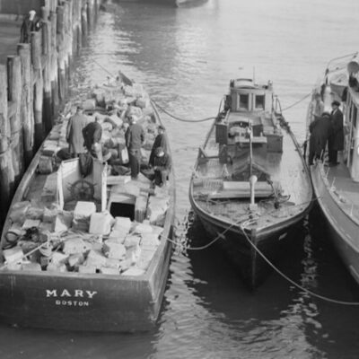 Photo: An apprehended rumrunner loaded with liquor shown docked alongside a Coast Guard 75-foot patrol boat