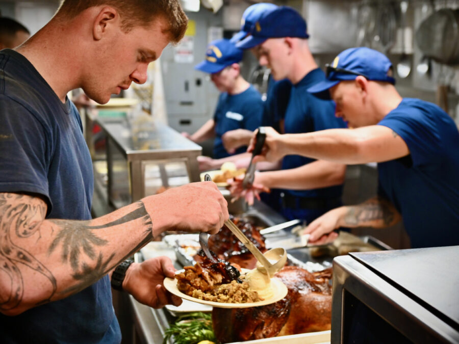 A seaman serves himself turkey and fixings in the galley.