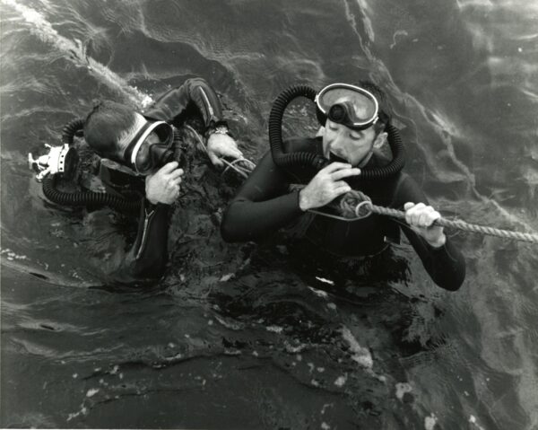Photo: Two divers hold onto a rope.