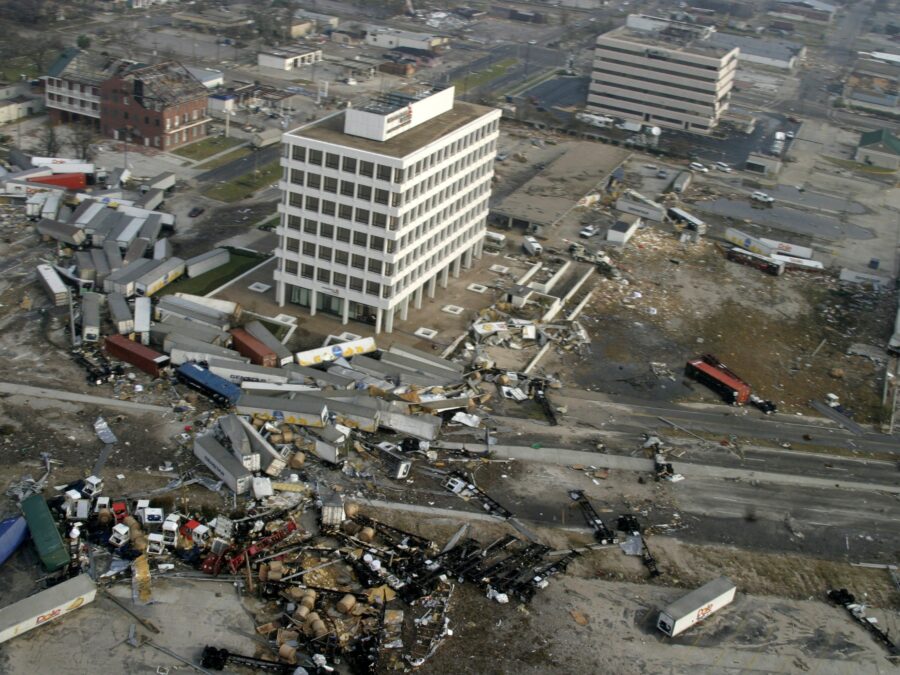 Photo: Pictured here are a few large building structures that are still standing, while many others have been completely wiped away. Trucks and cars are strewn about.