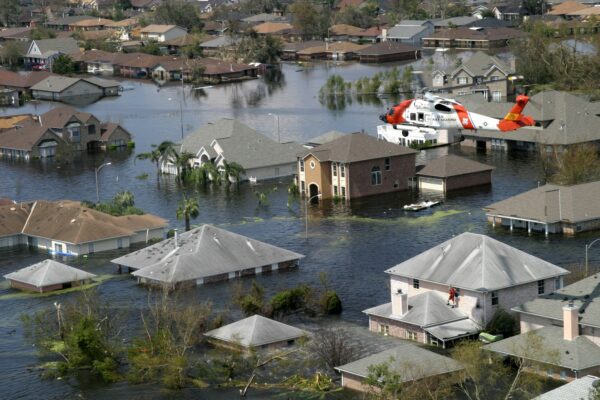 Photo: A Coast Guard rescue swimmer peers inside a home submerged by flood water due to Hurricane Katrina.