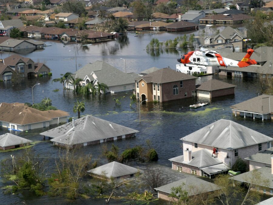 Photo: A Coast Guard rescue swimmer peers inside a home submerged by flood water due to Hurricane Katrina.